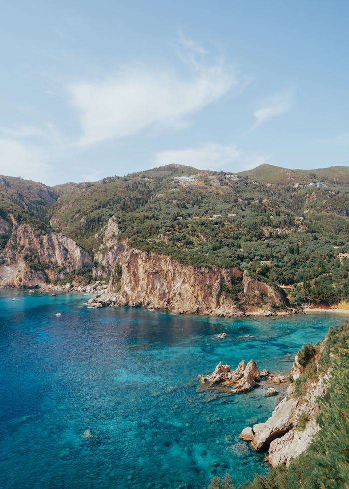 Discover the stunning cliffs and turquoise waters of Kerkyra's coastline in this vibrant summer landscape.